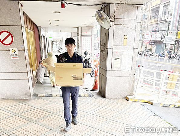 ▲一隻黑狗今天上午被閃電嚇傻衝進桃園區永安路上某家中醫診所，桃園警分局巡官黃培樺以紙箱包裝帶回分局。（圖／記者沈繼昌翻攝）